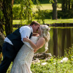 Bride and groom kissing under a willow tree, near a lake in Gatlinburg Tennessee.