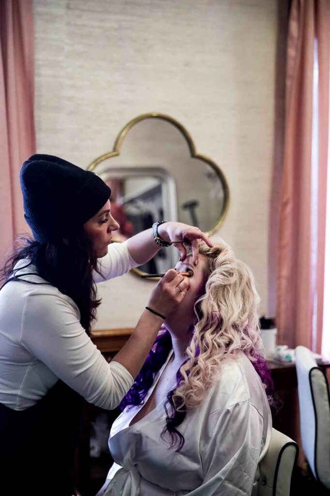 Wedding makeup artist perfecting a bride’s eye makeup during her bridal prep session.
